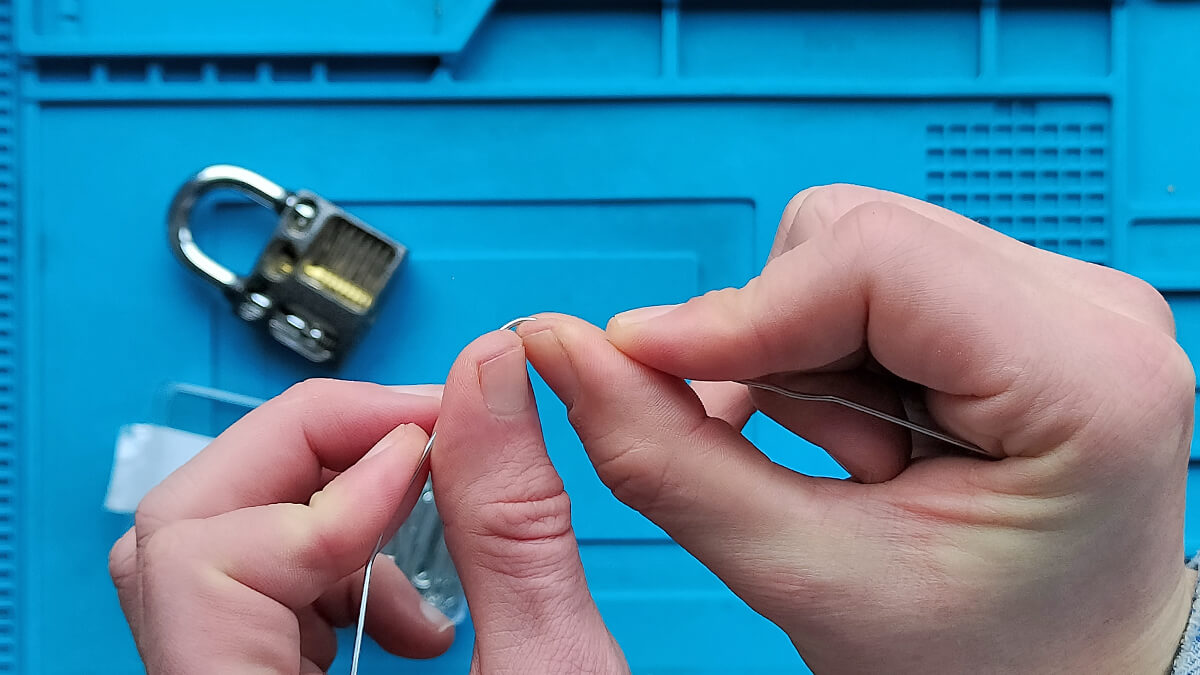 Paperclip buigen met twee handen om er een hangslot mee te openen