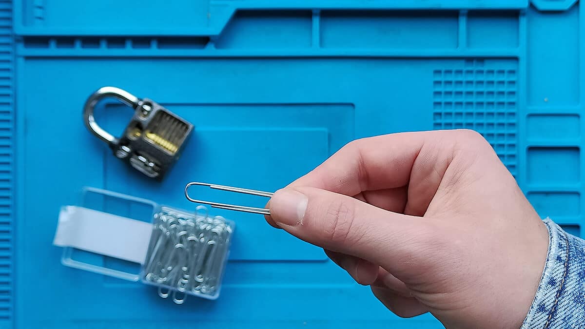 Een paperclip op de foto met een hangslot op de achtergrond.